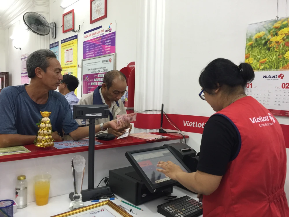 Người chơi vé số mua vé tại cửa hàng 879 Nguyễn Trãi, quận 5. Ảnh: Quỳnh Như