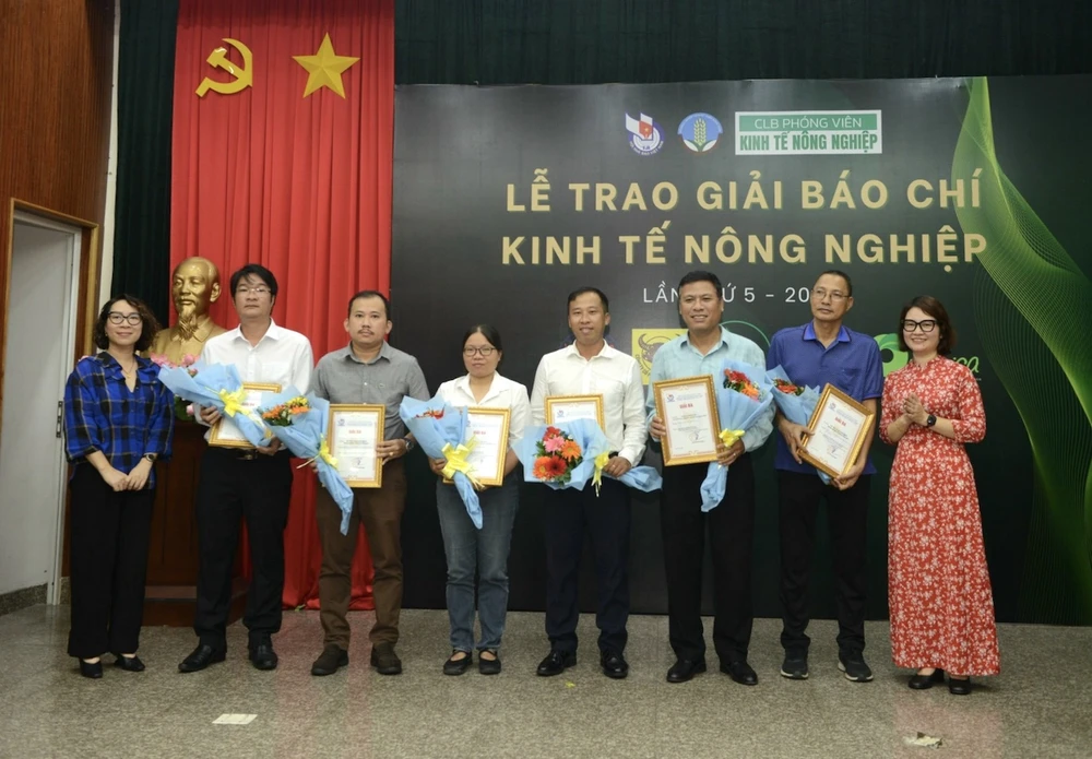 Phóng viên Lê Quang Huy, báo Pháp Luật TP.HCM (đứng giữa, thứ tư từ phải qua) đại diện nhận giải Giải báo chí kinh tế nông nghiệp với loạt bài "Gỡ thẻ vàng cho thủy sản Việt". Ảnh: Mạnh Linh Pháp Luật TP.HCM đoạt giải báo chí kinh tế nông nghiệp