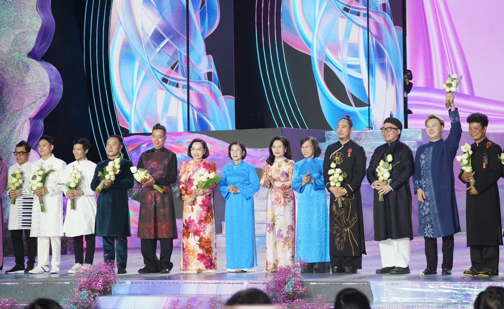 Các lãnh đạo và nguyên lãnh đạo TP.HCM tặng hoa cho các nhà thiết kế tham gia lễ hội Áo dài năm nay. Ảnh: THUẬN VĂN lễ hội áo dài