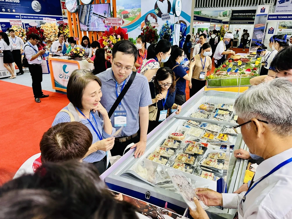 Khách hàng tham quan một gian hàng thủy sản tại triễn lãm. ẢNH: THU HÀ