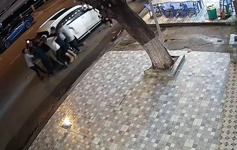 Lái xe và người bạn bị nhóm thanh niên hành hung. Ảnh cắt từ camera. Lái xe và người bạn bị nhóm thanh niên hành hung. Ảnh cắt từ camera.