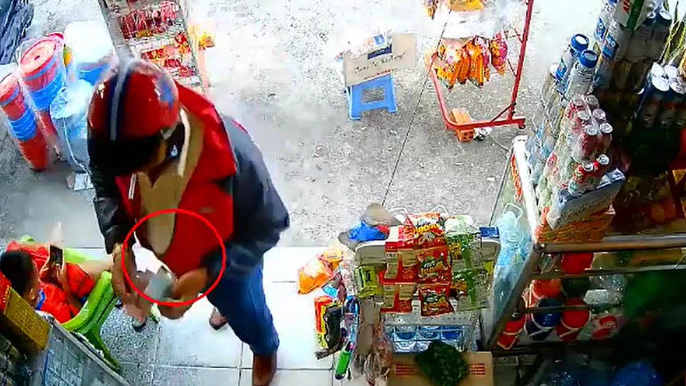 Người đàn ông tráo tiền tại một tiệm tạp hóa.