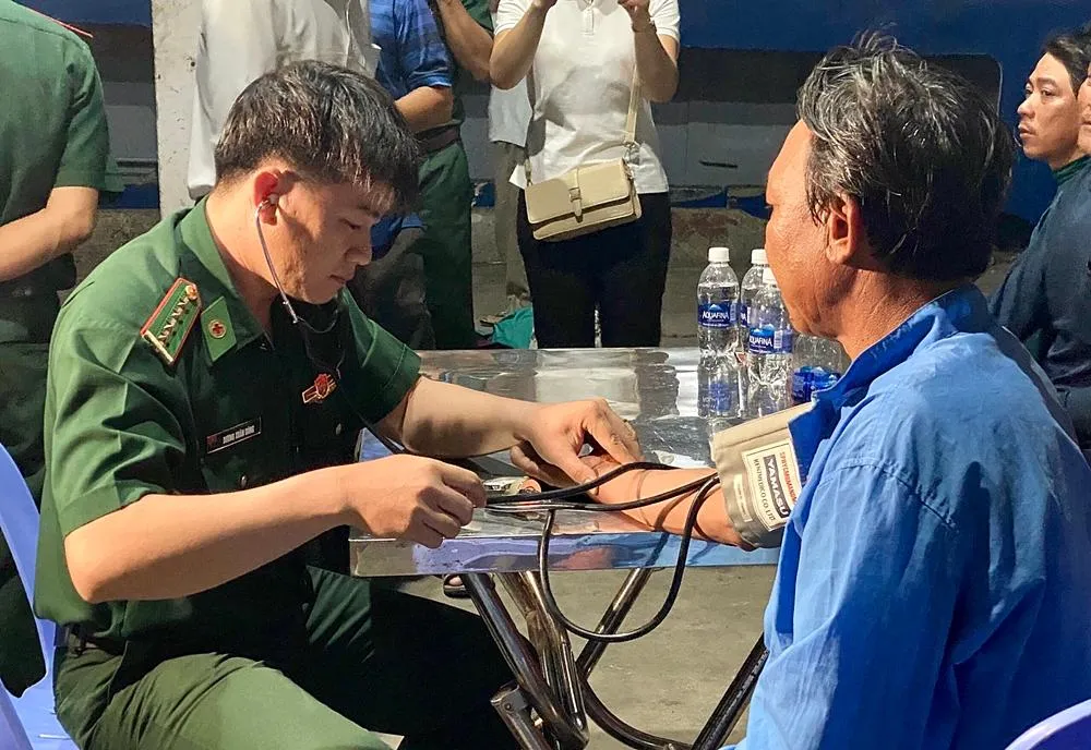 Biên phòng Bình Thuận chăm sóc y tế cho các thuyền viên gặp nạn. Ảnh: TRUNG THÀNH