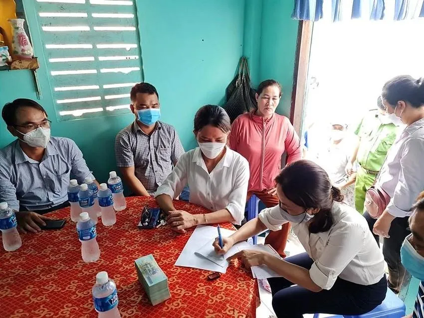 Đại diện UBND phường Lạc Đạo và Ngân hàng chính sách xã hội Bình Thuận phối hợp với Báo Pháp Luật TPHCM trao tiền bạn đọc giúp đỡ cho gia đình bé Linh. Ảnh Phương Nam.