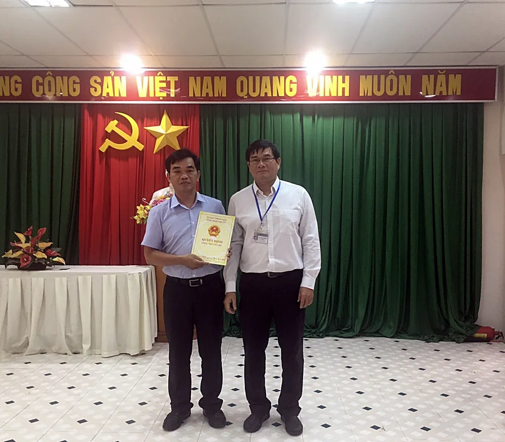 Ông Đỗ Thái Dương (phải) Gíam đốc Sở Nội vụ trao quyết định phân công cho BS Đặng Thức Anh Vũ.