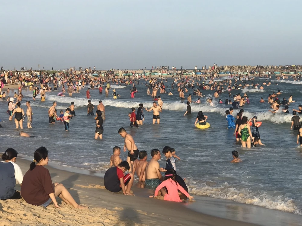 Du khách tắm biển tại bãi Đá ông địa.