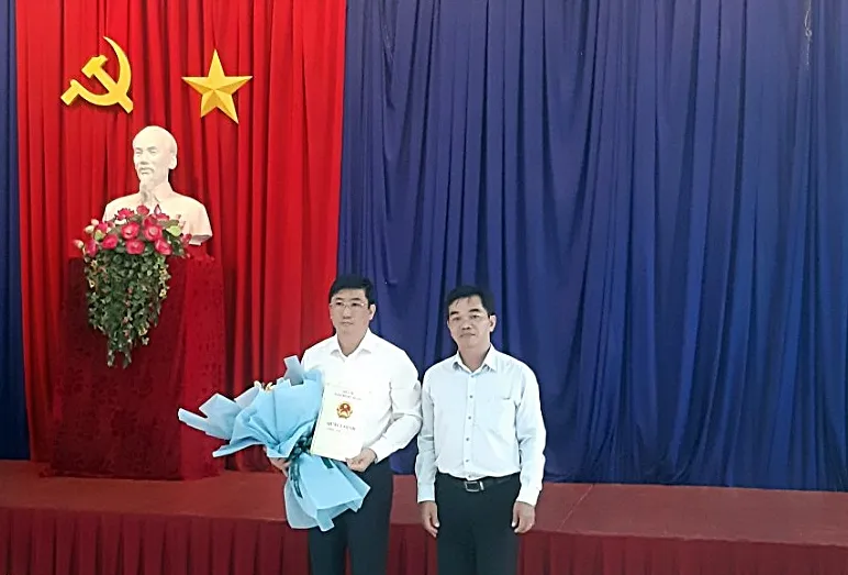 Bác sĩ Đặng Thức Anh Vũ (phải) trao quyết định và tặng hoa chúc mừng bác sĩ Lê Huỳnh Phúc. Ảnh MA