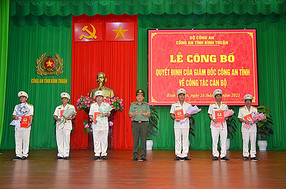Đại tá Trần Văn Mười, Phó Giám đốc Công an Bình Thuận, trao quyết định, tặng hoa cho 6 sĩ quan được điều động, bổ nhiệm nhận nhiệm vụ mới. Ảnh NHƯ Ý. điều động