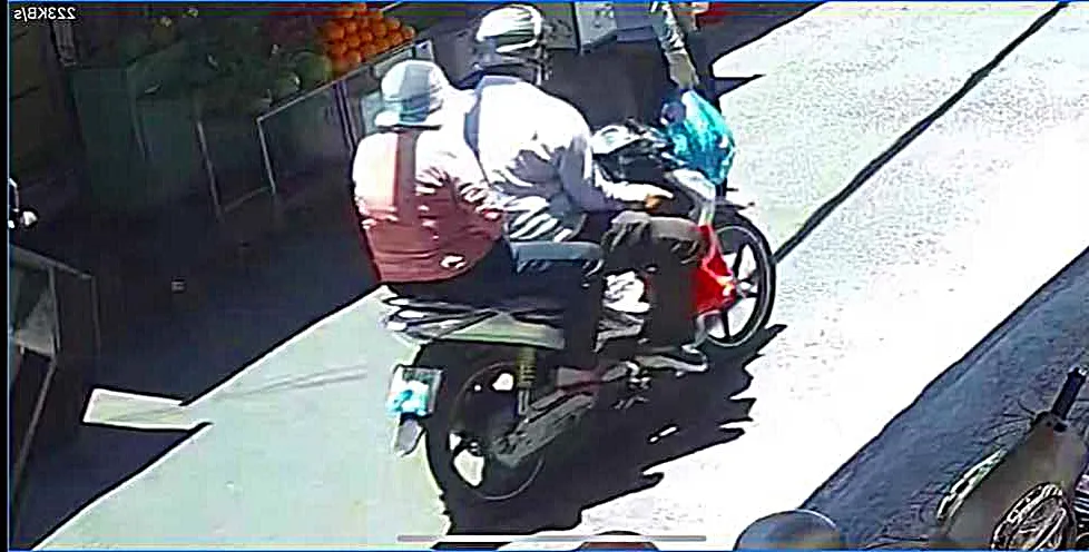 Hình ảnh đôi nam nữ dùng khẩu trang che biển số rời khỏi tiệm vàng. tiệm vàng