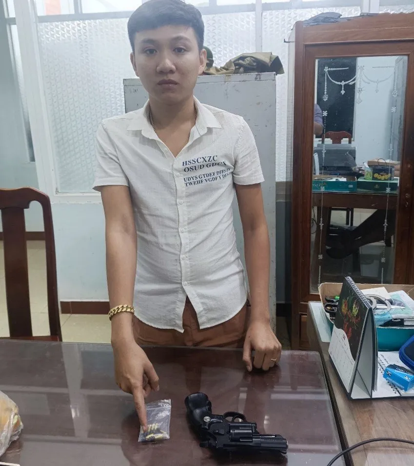 Nguyễn Duy Khánh cùng số súng đạn tang vật. Ảnh: PV01 vu-khi (1).jpg