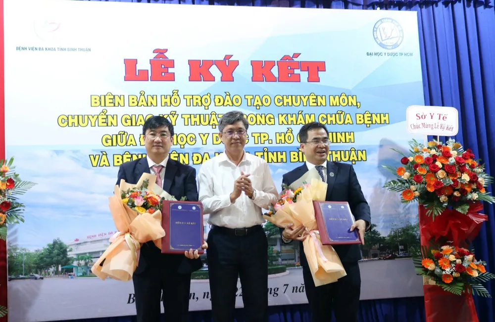 Ông Nguyễn Minh, Phó Chủ tịch UBND tỉnh Bình Thuận (giữa) tặng hoa chúc mừng BS Lê Huỳnh Phúc, Giám đốc Bệnh viện Đa khoa Bình Thuận (trái) và PGS.TS.BS Ngô Quốc Đạt, Phó Hiệu trưởng phụ trách Đại học Y dược TP.HCM sau lễ ký kết. dai-hoc-y-duoc (1).jpg