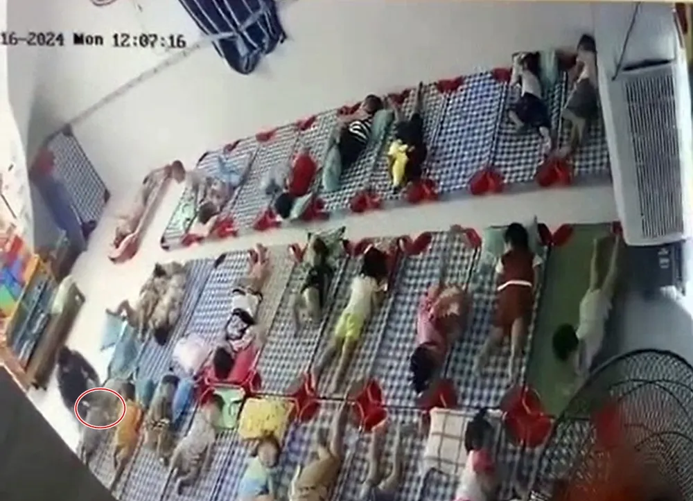 Bé TKQ bị bảo mẫu đè gối lên mặt. Ảnh cắt từ clip bao-hanh-tre-em (1).jpg