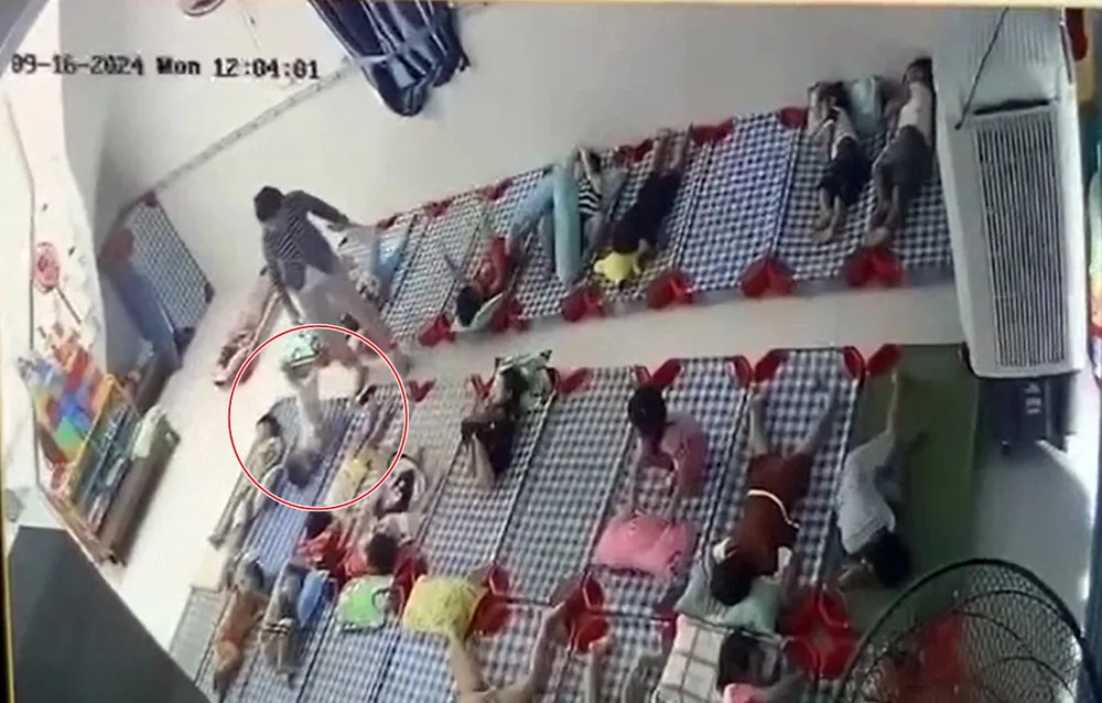 Đứa bé bị bảo mẫu lớn tuổi đá ngã cắm đầu xuống nệm. Ảnh cắt từ clip bạo hành trẻ em