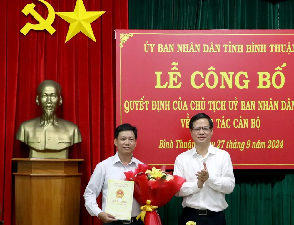 Ông Đoàn Anh Dũng (phải), Chủ tịch UBND tỉnh Bình Thuận trao quyết định và tặng hoa chúc mừng tân giám đốc Sở Nội vụ. sở nội vụ