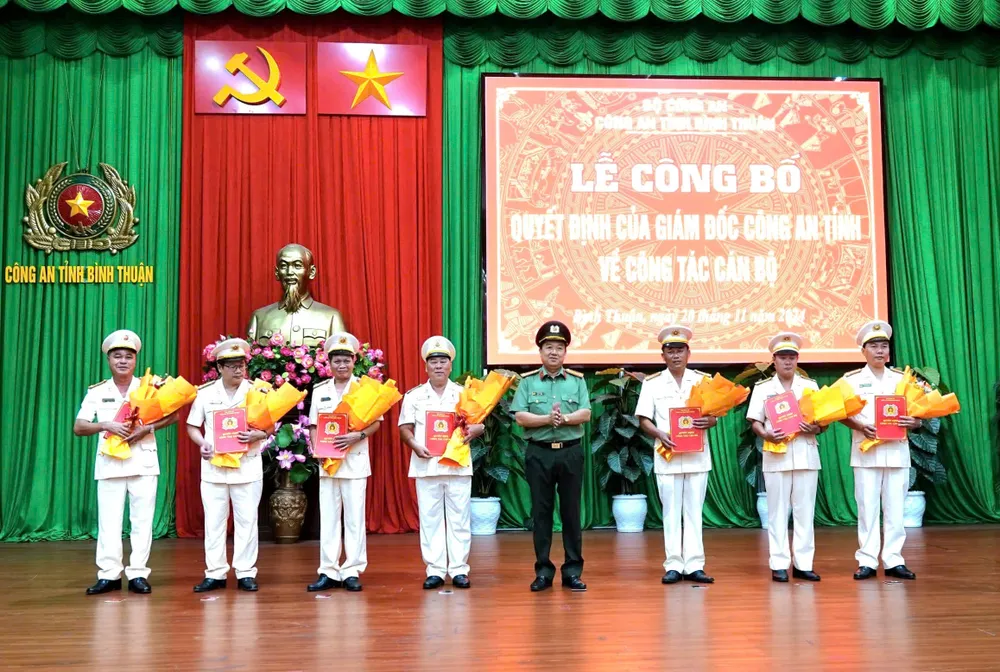 Đại tá Trần Văn Mười, Phó Giám đốc Công an Bình Thuận trao quyết định và tặng hoa cho các sĩ quan vừa được điều động. Công an Bình Thuận