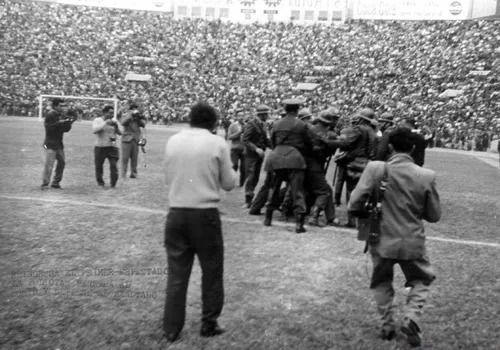 Cảnh sát tấn công một CĐV nhảy vào sân trong trận đấu năm 1964. a-2494-1401188263.jpg