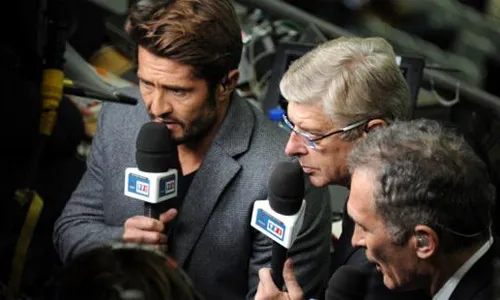 Wenger (giữa) cùng bình luận với cựu hậu vệ Bixente Lizarazu trongmột trận đấu của tuyển Pháp. Ảnh: Le Figaro. WWenger-4595-1409908617.jpg