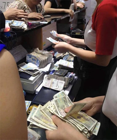 Nhân viên cửa hàng đếm tiền của chị Hằng.