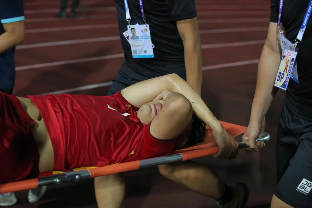 Văn Xuân rời sân trên cáng trong đau đớn. ẢNH: ANH PHƯƠNG Văn Xuân rời sân trên cáng trong đau đớn. ẢNH: ANH PHƯƠNG