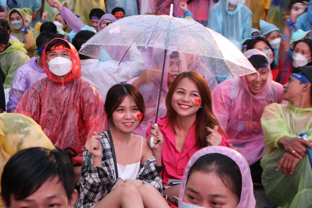 Dù trời đổ mưa nhưng nhiều CĐV vẫn tập trung về phố đi bộ Nguyễn Huệ (quận 1, TP.HCM) để 'tiếp lửa' cho đội nhà. Ảnh: HUỲNH THƠ