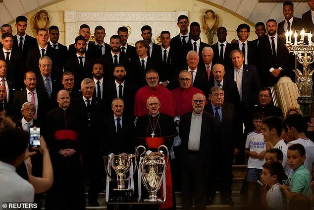 Chủ tịch Florentino Perez, HLV Carlo Ancelotti, dàn cầu thủ Real Madrid cùng 2 chiếc cúp La Liga và Champions League tại nhà thờ Catedral de la Almudena. ẢNH: REUTERS