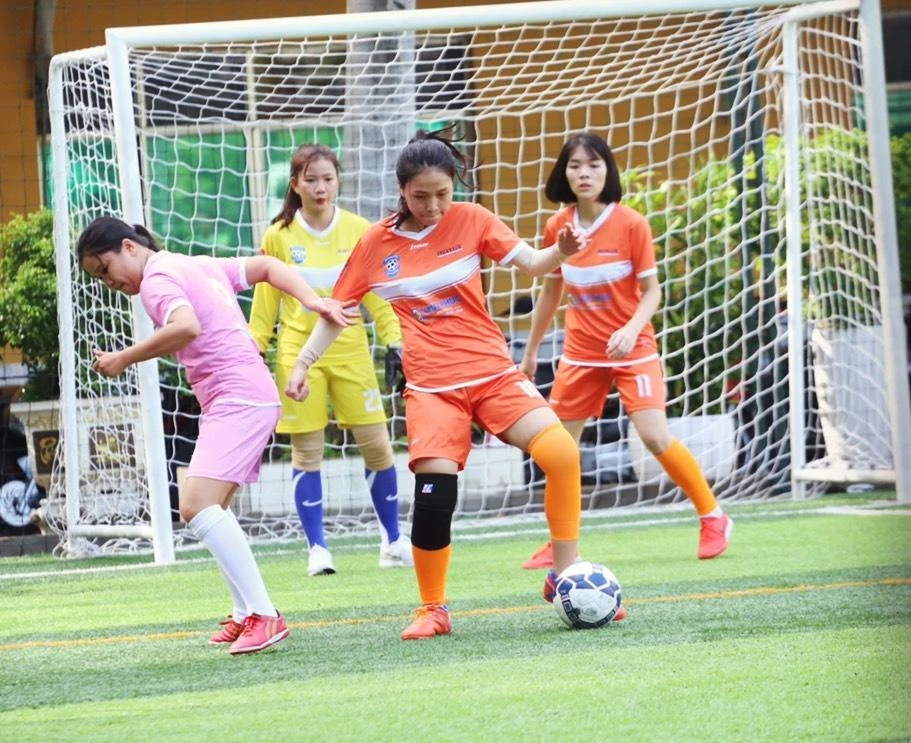 Huyền Vân (áo cam) tranh bóng cùng cầu thủ SGGP.