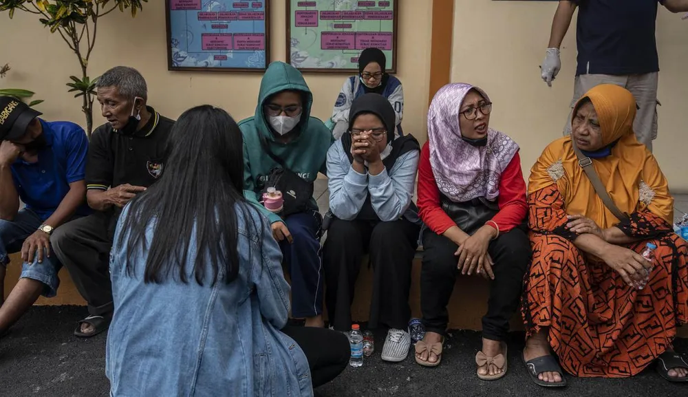 Gia đình người nhà các nạn nhân đang chờ đợi và cầu nguyện bên ngoài một bệnh viện ở Malang, Đông Java. ẢNH: BOLA