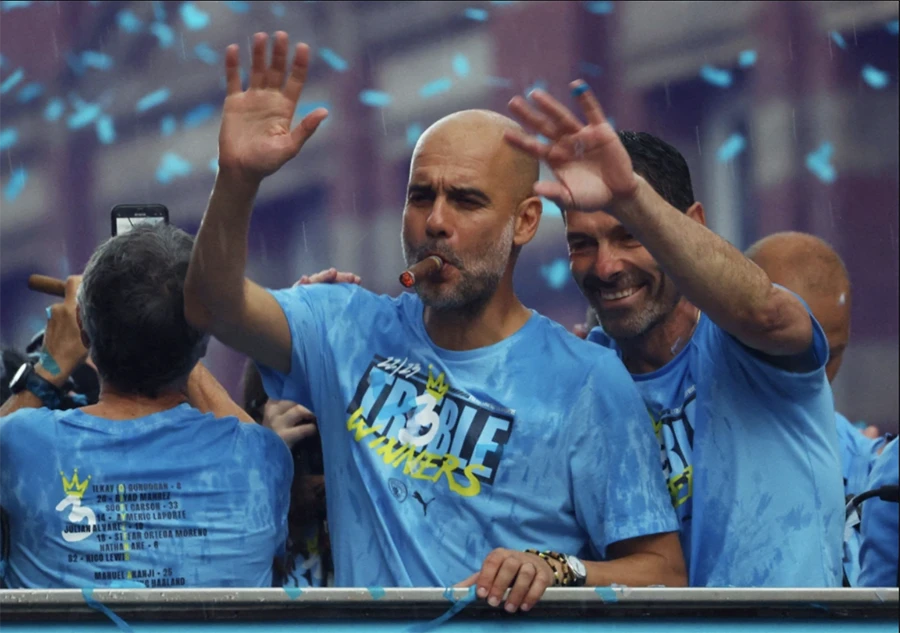 Pep Guardiola xuất hiện "cực ngầu" trong lễ diễu hành ăn mừng cú ăn ba lịch sử của Man City. ẢNH: AFP, REUTERS