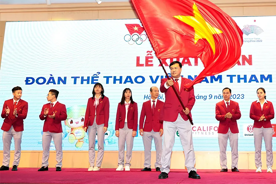 Trưởng đoàn thể thao Việt Nam tại ASIAD 19 Đặng Hà Việt phất cờ trong lễ xuất quân. Ảnh: TTVN IMG_6026.jpeg
