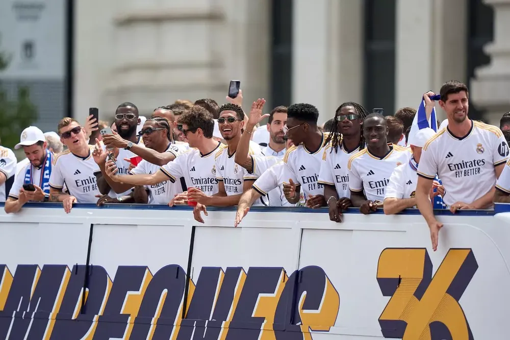 Các cầu thủ Real Madrid được chào đón bởi người hâm mộ trong cuộc diễu hành trên xe buýt mui trần. ẢNH: GETTY real-madrid-vo-dich-la-liga-3.jpg