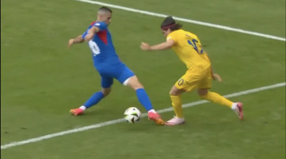 Ianis Hagi của Romania bị David Hancko giẫm lên chân bên ngoài vòng cấm, trong pha phạm lỗi đầu tiên dẫn đến quả penalty nực cười. ẢNH: SUN SPORTS quả penalty nực cười