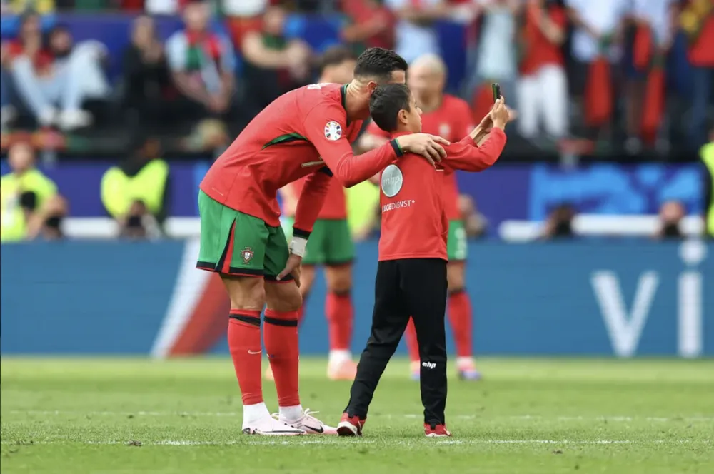 Ronaldo chụp ảnh với fan nhí lao vào sân cố tiếp cận anh. ẢNH: GETTY euro-2024-cristiano-ronaldo.png