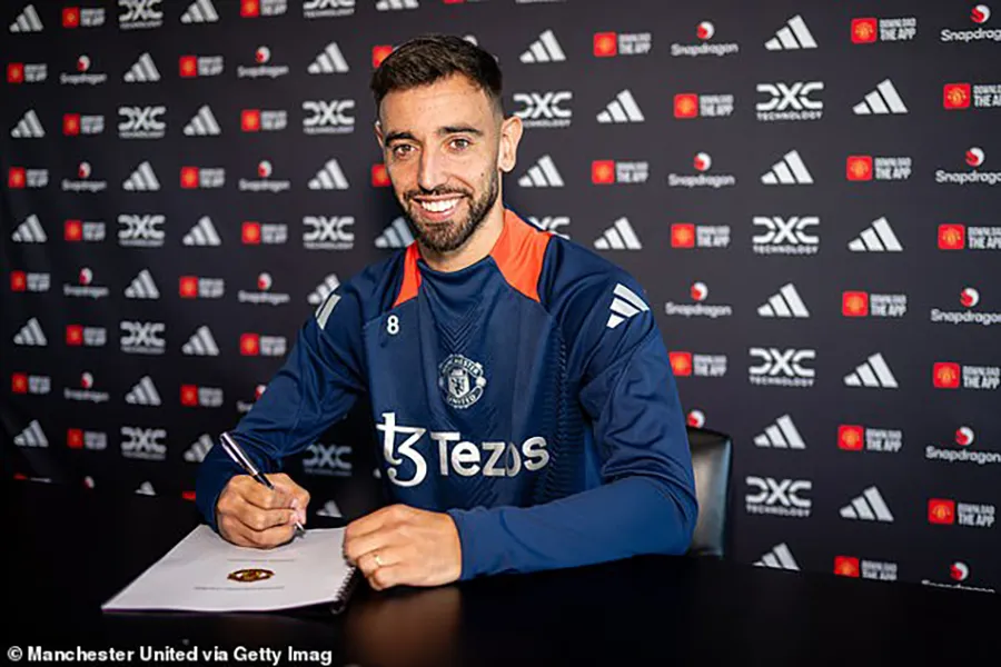 Bruno Fernandes tươi cười ký vào bản hợp đồng mới với MU. ẢNH: GETTY chia tay MU,BRUNO FERNANDES,MU