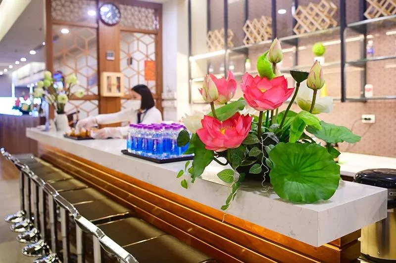 Hành khách được tiếp đón với quầy thủ tục trang trí hoa sen. Ảnh: VNA Hành khách được tiếp đón với quầy thủ tục trang trí hoa sen. Ảnh: VNA