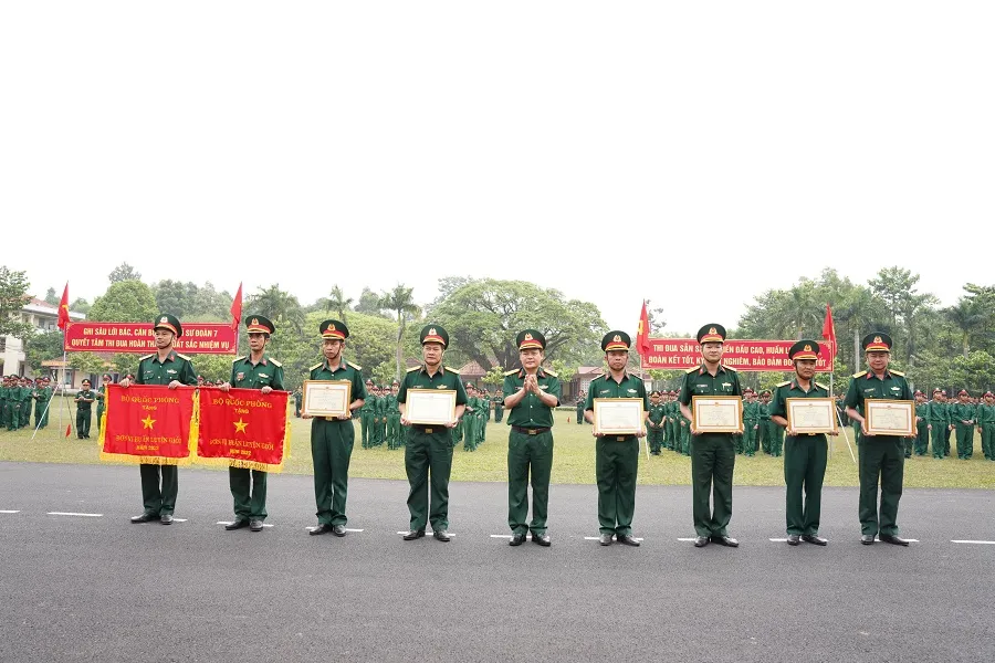 Đại tá Nguyễn Trần Long, Phó Chính ủy Quân đoàn 4 trao cờ Huấn luyện giỏi của Bộ Quốc phòng năm 2022 cho trung đoàn 209 và Trung đoàn 141. Ảnh: LÊ BA