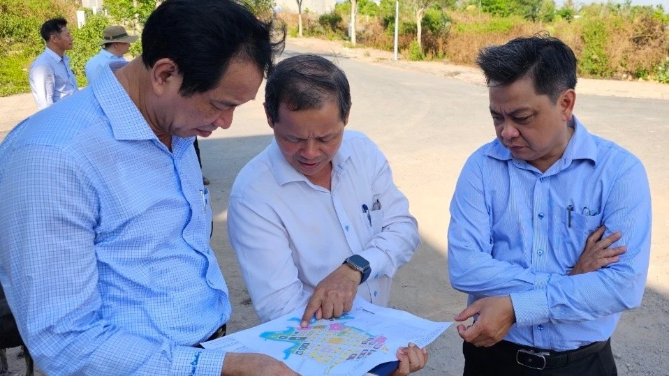 Phó Chủ tịch UBND tỉnh Đồng Nai Võ Văn Phi (bên trái) nghe đại diện Công ty CP An Hưng Phát trình bày vị trí xây nhà ở xã hội trong dự án. Ảnh: VH. tai-dinh-cu-cao-toc-bien-hoa.jpg