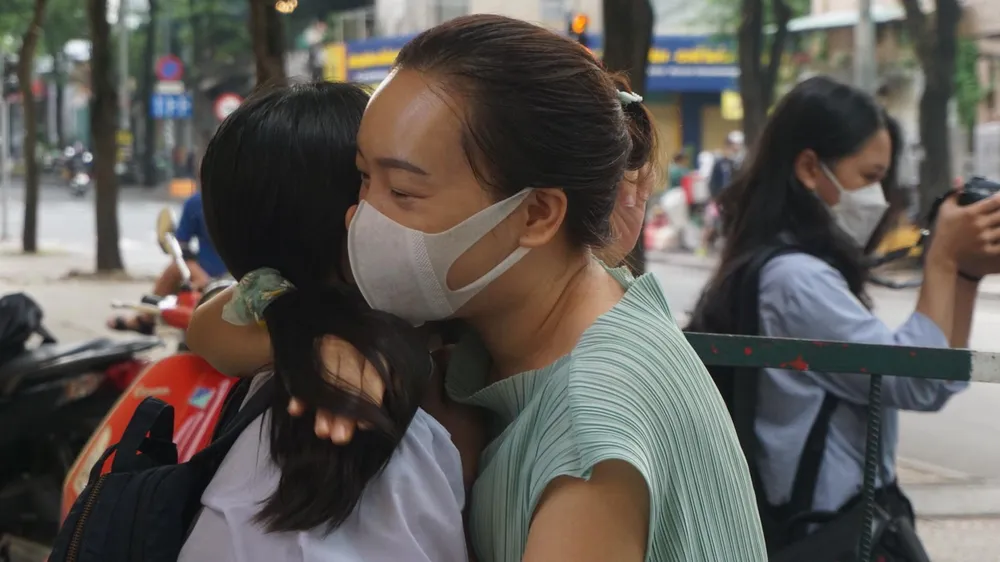 Để tránh tình trạng ùn tắc trước cổng trường, phụ huynh sau khi đưa con đến điểm thi sẽ không ở lại lâu. Thí sinh sẽ được bảo vệ cùng các anh, chị hướng dẫn đi vào khu vực thi. Trước khi tạm biệt con, chị Nguyễn Ngọc Thuỳ, quận Gò Vấp ôm con động viên. Chị Thuỳ nói: &quot;Khi biết đây là môi trường học tập tốt, tôi muốn cho con thử sức. Tôi không đặt nặng việc con phải đậu, chỉ mong con có một sự trải nghiệm để biết năng lực của mình đến đâu. Năm nay đề thi có chút thay đổi cũng là điều thú vị. Tôi không cho con ôn luyện ở đâu, cháu tự học là chính&quot;.