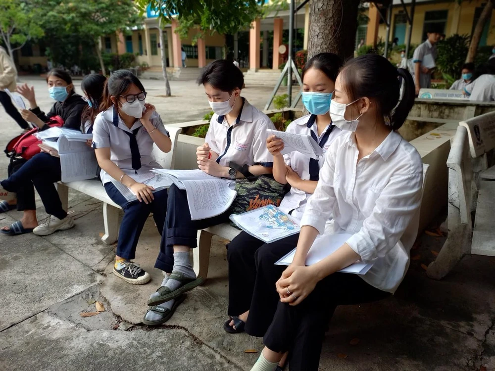 Thí sinh tranh thủ ôn bài trước giờ thi. Ảnh: PHẠM ANH