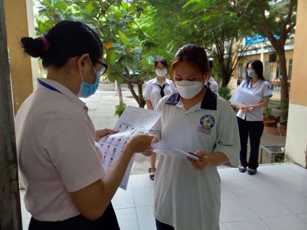 Giám thị rà soát thông tin của từng thí sinh trước khi vào phòng thi. Ảnh: PHẠM ANH