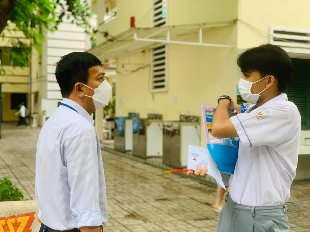 Giám thị hướng dẫn thí sinh vào phòng thi. Ảnh: THẢO PHƯƠNG