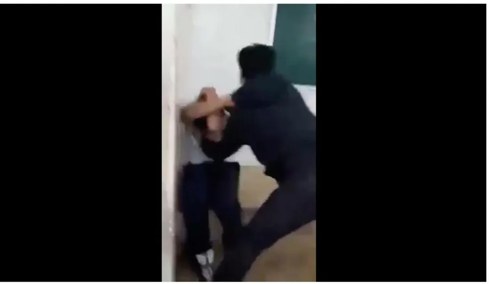 Nam sinh áo trắng bị bạn đánh liên tục. Ảnh cắt từ clip