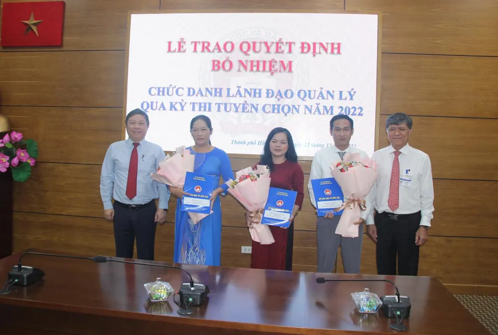 Ông Dương Anh Đức, Phó Chủ tịch UBND TP.HCM (bìa trái) và ông Nguyễn Văn Hiếu, Giám đốc Sở GD&ĐT TP.HCM (bìa phải) trao quyết định bổ nhiệm cho 3 ứng viên trúng tuyển. Ảnh: NGUYỄN QUYÊN trao quyết định bổ nhiệm