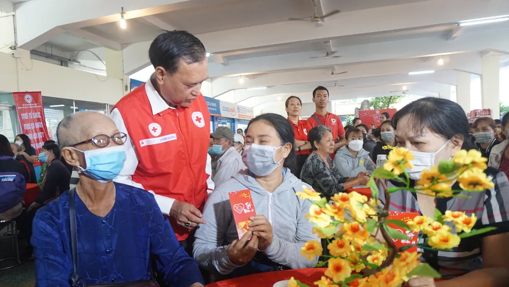 Ông Trần Trường Sơn, Chủ tịch Hội Chữ Thập đỏ TP.HCM tặng bao lì xì cho các gia đình tham dự. Ảnh: NGUYỄN QUYÊN “Tết nhân ái” đong đầy yêu thương