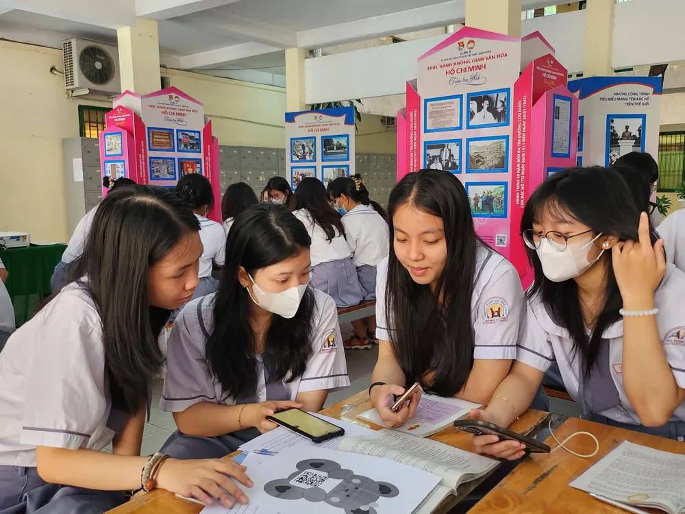 Học sinh dùng điện thoại, quét mã QR để tìm hiểu tư tưởng của Bác Hồ về dân chủ, qua đó vận dụng vào thực tiễn hiện nay.