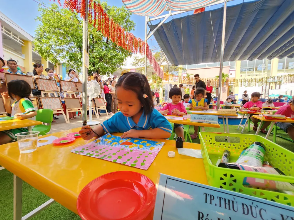 Bé Hà Thảo Chi chăm chú hoàn thành bức vẽ.