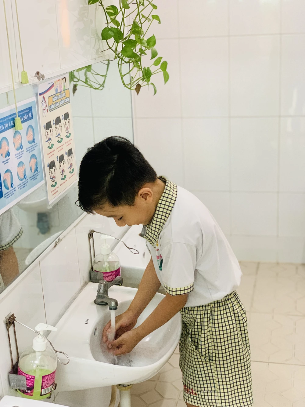 Sau khi rửa tay tại khuôn viên trường, các bé được giáo viên hướng dẫn tiếp tục rửa tay trước khi vào giờ học.
