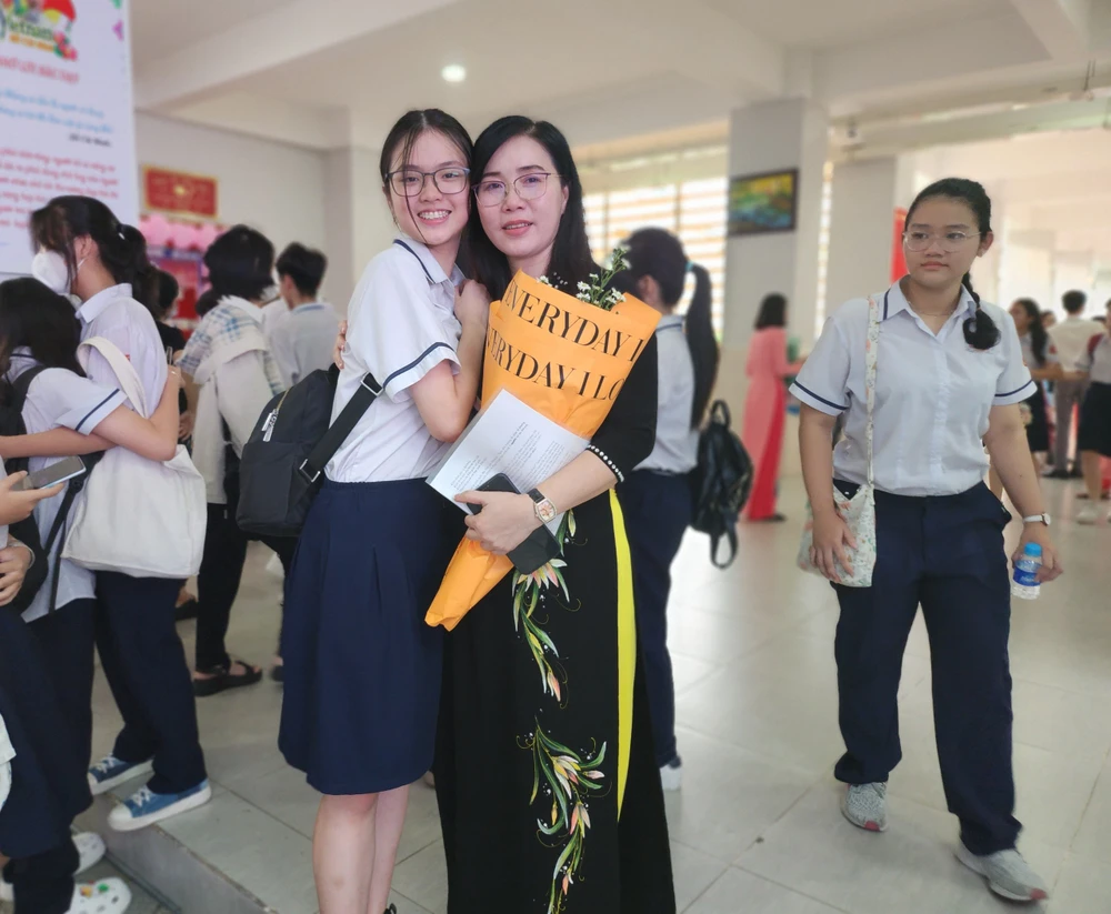 Cô Lê Thị Thuỳ, Hiệu trưởng Trường THCS Vân Đồn, quận 4 cùng học trò trong lễ tri ân. Ảnh: NGUYỄN QUYÊN