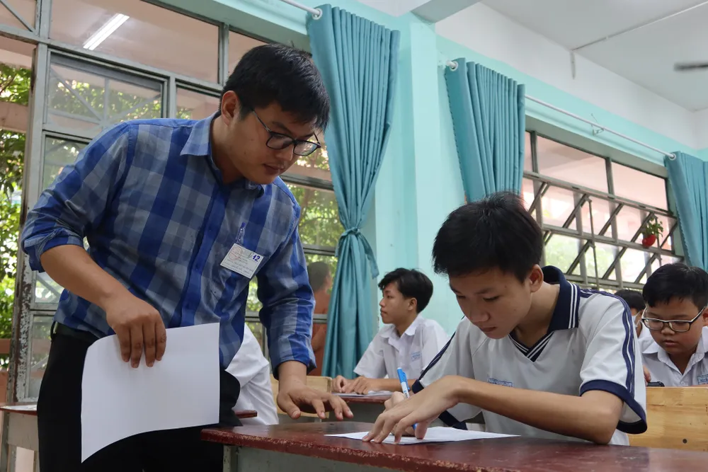 Giám thị kiểm tra hồ sơ của thí sinh. Ảnh: TRẦN MINH