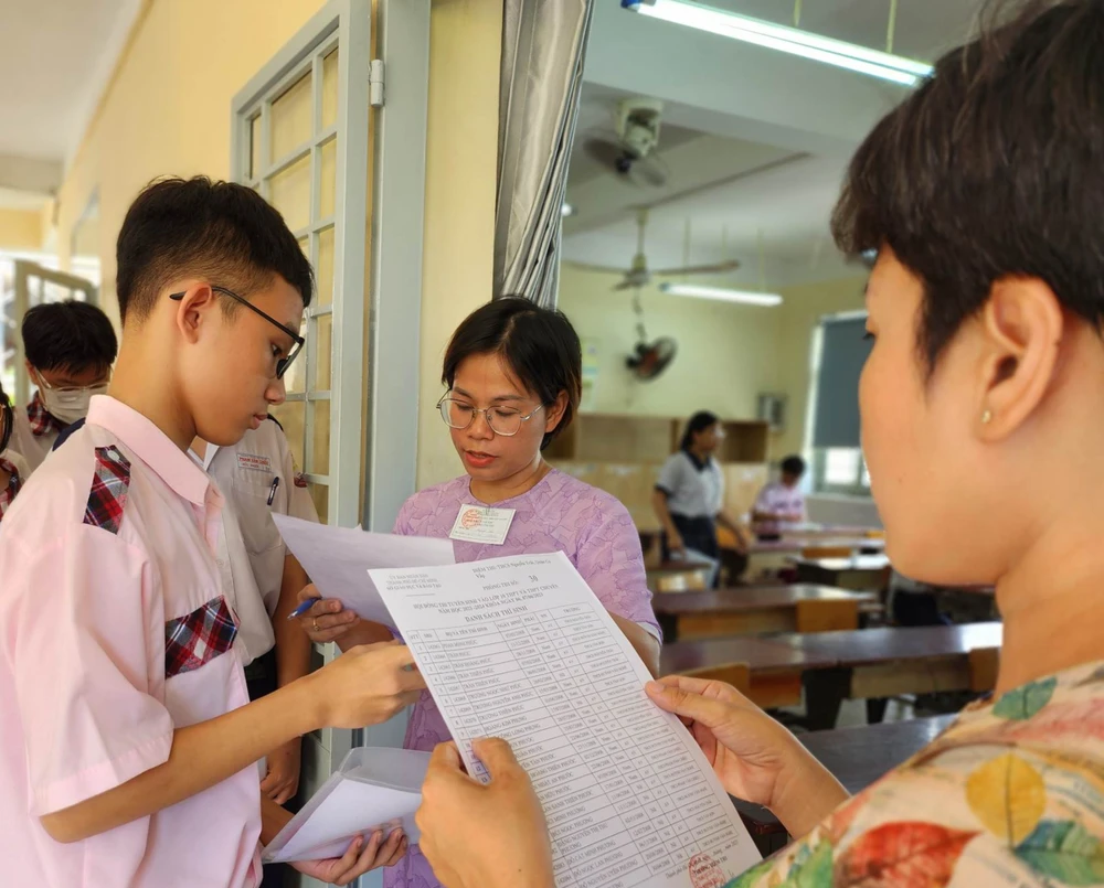 Giám thị kiểm tra giấy tờ của thí sinh trước giờ thi môn ngoại ngữ. Ảnh: NGUYỄN QUYÊN