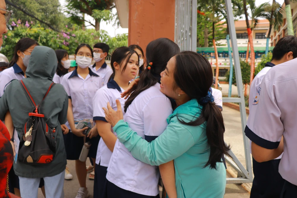 Giáo viên Trường THCS Hoa Lư, TP Thủ Đức đến điểm thi động viên học trò. Ảnh: VÕ THƠ